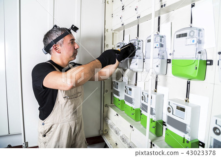 Electrician engineer works on fuse switch box 43023378
