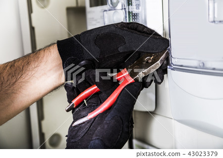 Electrician connecting wires in distribution board 43023379