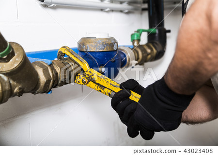 Plumber repairing water pipes with manometer 43023408
