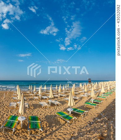 White sandy beach with sunshades and sunbeds White sandy beach with sunshades and sunbeds 43032092