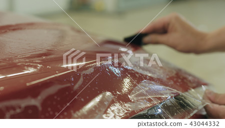 professional applying protective film to the red car professional applying protective film to the red car 43044332