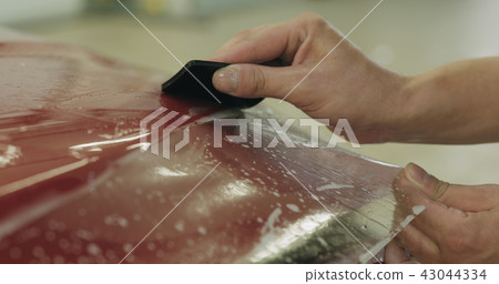 professional applying protective film to the red car professional applying protective film to the red car 43044334