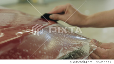 professional applying protective film to the red car professional applying protective film to the red car 43044335
