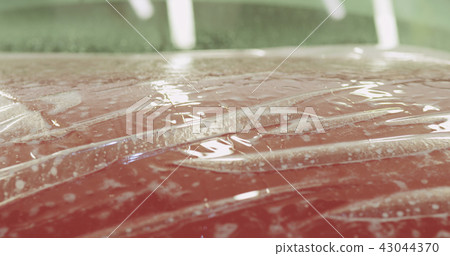 applying protective film to the red car applying protective film to the red car 43044370