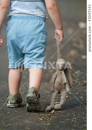 child walking in the street with rabbit in hand 43045541