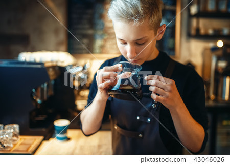 Male barista sniffs fresh prepared black coffee 43046026