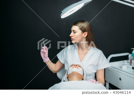 Beautician with syringe in hands, botox injection Beautician with syringe in hands, botox injection 43046114