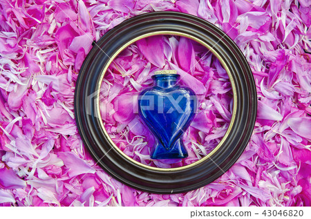 frame and vintage perfume bottle on peony petals  43046820