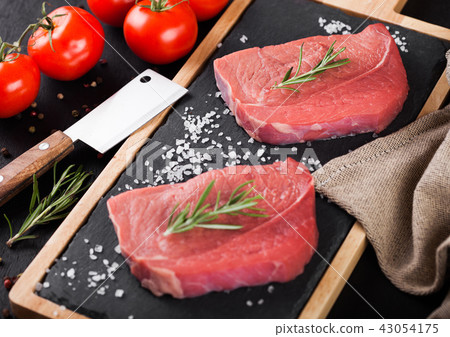 Fresh raw beef steak meat on board with hatchet Fresh raw beef steak meat on board with hatchet 43054175