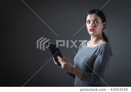 Young woman using her tablet Young woman using her tablet 43054500