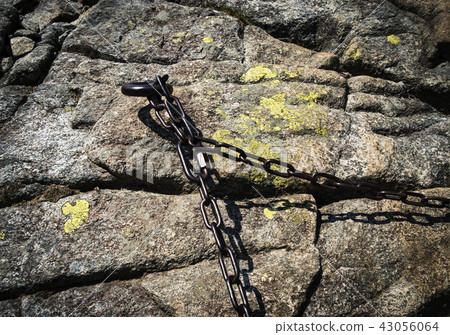 a rusty iron chain on a granite rock a rusty iron chain on a granite rock 43056064