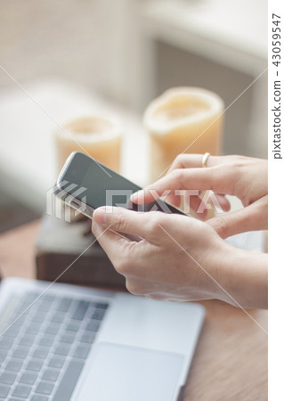 Woman using smart phone in coffee shop Woman using smart phone in coffee shop 43059547