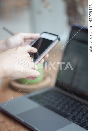 Woman using smart phone in coffee shop Woman using smart phone in coffee shop 43059548