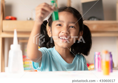 The little girl is testing color in glass and look 43060017