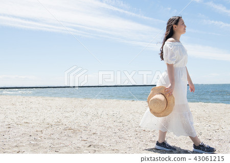 走在女孩沙灘的一名年輕日本婦女 走在女孩沙灘的一名年輕日本婦女 43061215