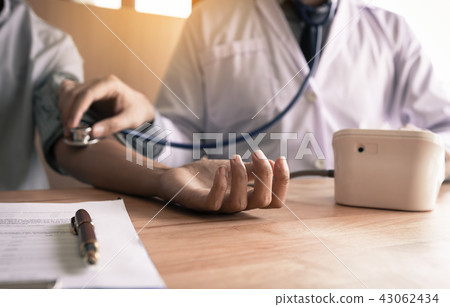 Doctor checking a senior patient's blood pressure 43062434