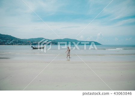 handsome girl on the beach background. Portrait of a woman in white clothes on the sea handsome girl on the beach background. Portrait of a woman in white clothes on the sea 43063846