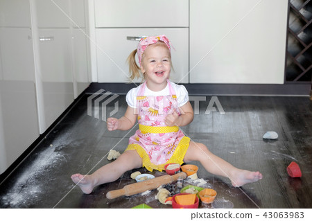Little girl making dough and cookies in kitchen 43063983