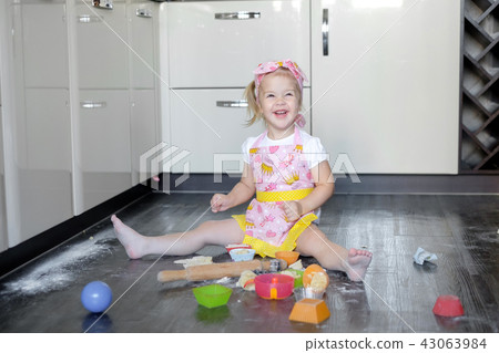 Little girl making dough and cookies in kitchen 43063984