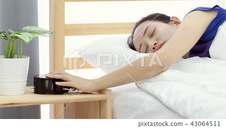 lazy asian woman refusing to wake up lying on her bed lazy asian woman refusing to wake up lying on her bed 43064511