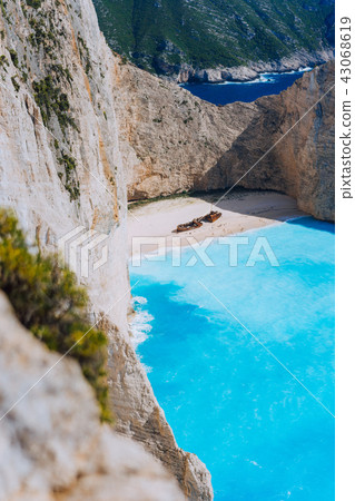 Limestone chalk colored like huge cliff rocks surrounding Navagio beach with Shipwreck and azure Limestone chalk colored like huge cliff rocks surrounding Navagio beach with Shipwreck and azure 43068619