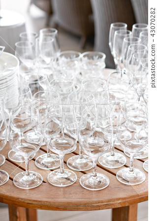 Clean plates, glasses and cutlery on wooden table. Catering set-up ready for the event to begin Clean plates, glasses and cutlery on wooden table. Catering set-up ready for the event to begin 43070282