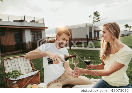 Beaming lady with male tasting alcohol beverage 43073012