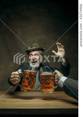 Smiling bearded male drinking beer in pub Smiling bearded male drinking beer in pub 43074466