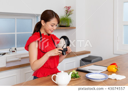 A woman taking a picture of cooking 43074557