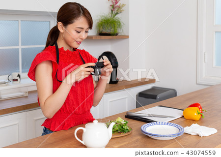 A woman taking a picture of cooking 43074559