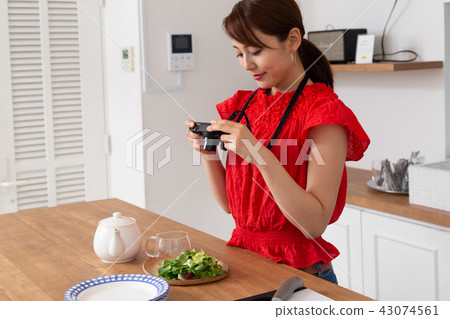 A woman taking a picture of cooking 43074561