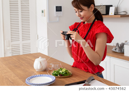 A woman taking a picture of cooking 43074562