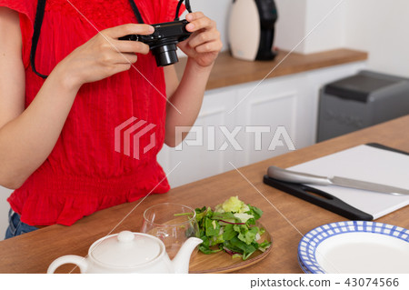 A woman taking a picture of cooking 43074566