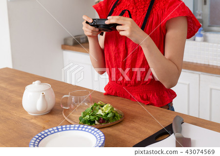 A woman taking a picture of cooking 43074569