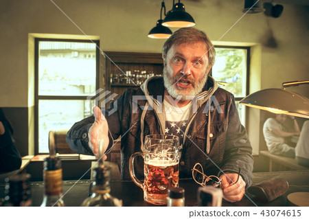 The senior bearded male drinking beer in pub 43074615