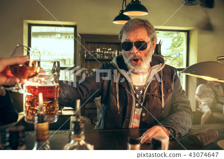 The senior bearded male drinking beer in pub The senior bearded male drinking beer in pub 43074647