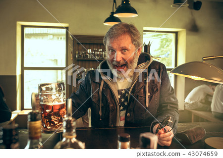 The senior bearded male drinking beer in pub 43074659