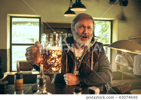 The senior bearded male drinking beer in pub 43074698