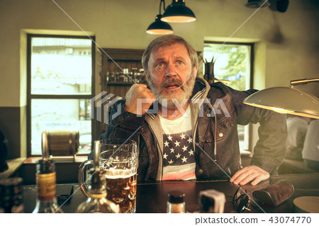 The senior bearded male drinking beer in pub 43074770