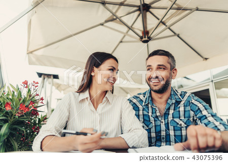 Smiling young couple working at cafe Smiling young couple working at cafe 43075396