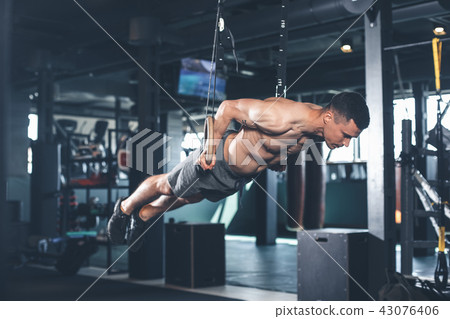 Strained man is doing back lever with rings Strained man is doing back lever with rings 43076406