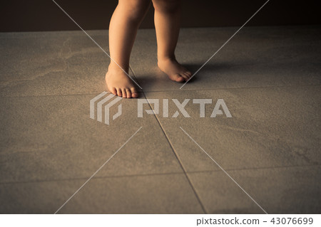 Barefoot baby are staying on heating tile floor. Barefoot baby are staying on heating tile floor. 43076699