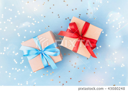 Two gift boxes wrapped in kraft paper with confetti. 43080248