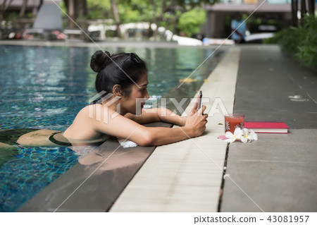Sexy woman in pool play smartphone 43081957