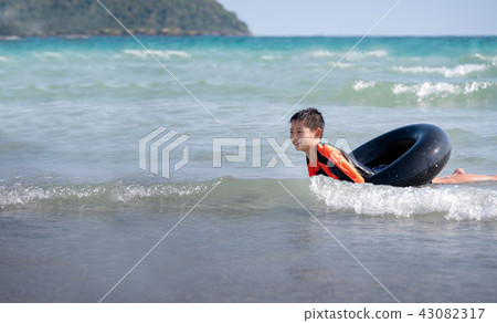 little Asian boy play waves on the beach  43082317