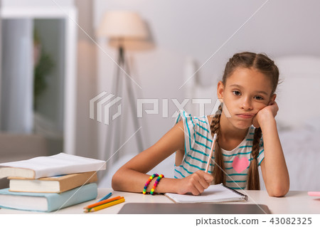 Cheerless nice girl holding her chin at home 43082325