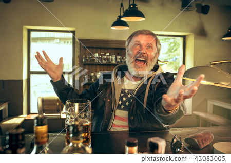 The senior bearded male drinking beer in pub 43083005