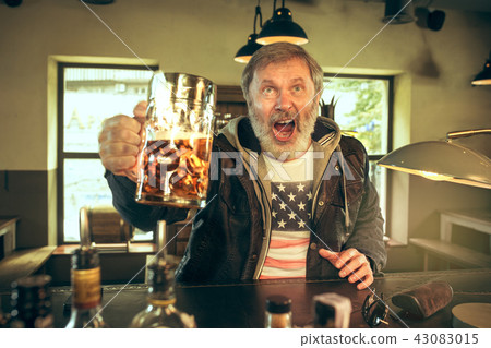 The senior bearded male drinking beer in pub 43083015