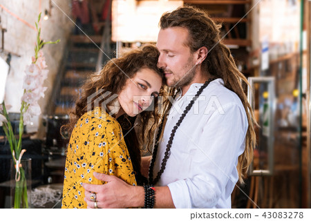 Curly dark-haired woman leaning on her strong man 43083278