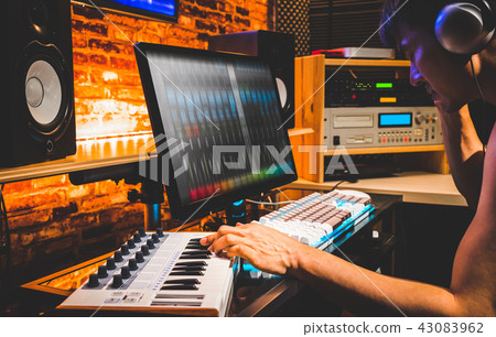 composer arranging music on computer in studio 43083962